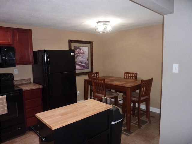 kitchen with black appliances, butcher block countertops, and light tile patterned floors