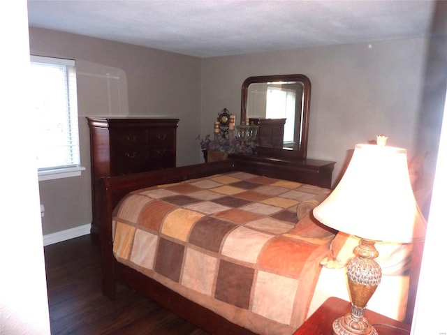 bedroom with dark hardwood / wood-style floors