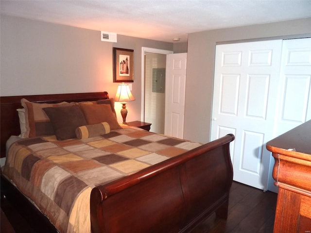 bedroom with dark hardwood / wood-style flooring and a closet