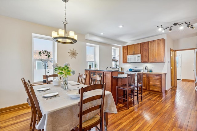 dining area with dark hardwood / wood-style floors, plenty of natural light, and a chandelier