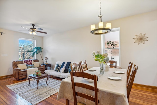 dining area featuring ceiling fan with notable chandelier and hardwood / wood-style floors