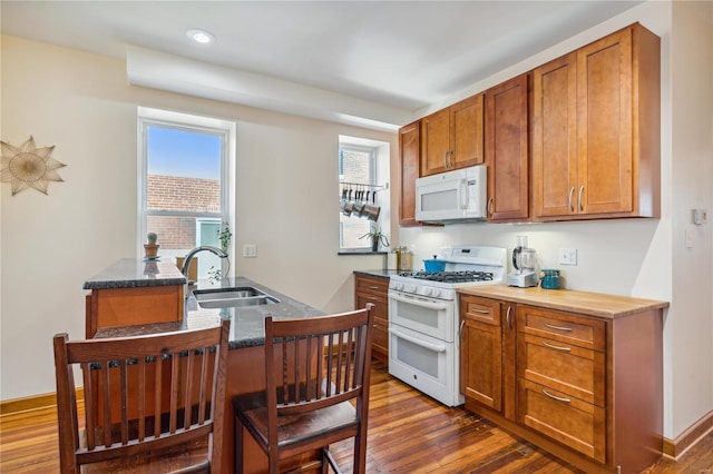 kitchen featuring dark wood-type flooring, sink, and white appliances