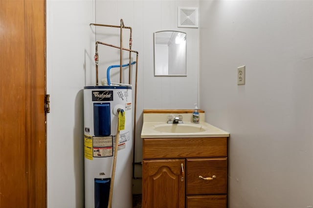bathroom with vanity, electric water heater, and visible vents