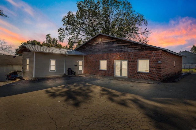 exterior space featuring brick siding and metal roof
