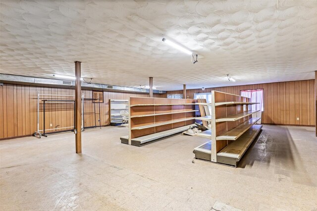 finished below grade area with wooden walls and tile patterned floors