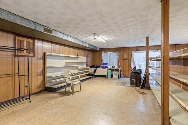 basement with light floors and wood walls