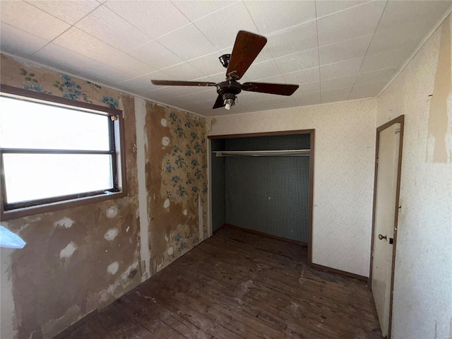 unfurnished bedroom featuring dark hardwood / wood-style flooring, a closet, and ceiling fan