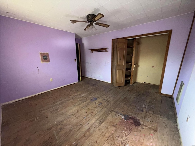 unfurnished bedroom with dark hardwood / wood-style flooring, a closet, and ceiling fan