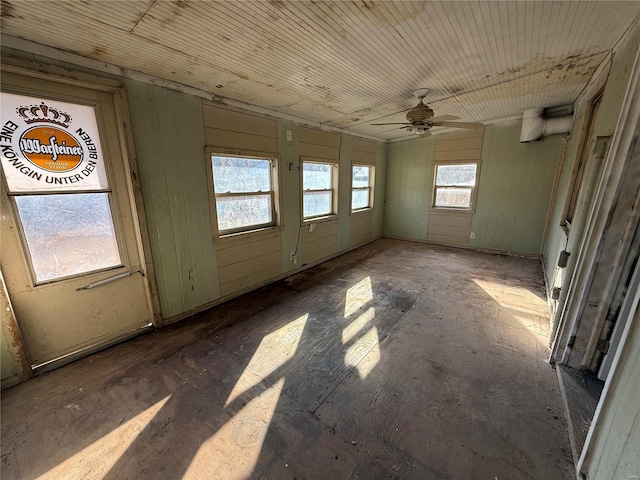 unfurnished sunroom featuring a wealth of natural light and ceiling fan