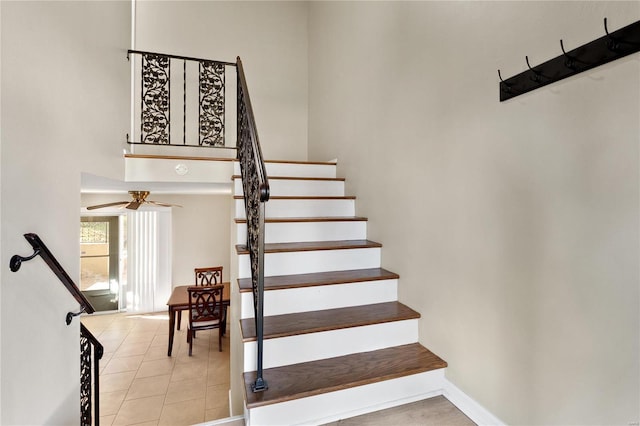 stairway featuring tile patterned floors and ceiling fan