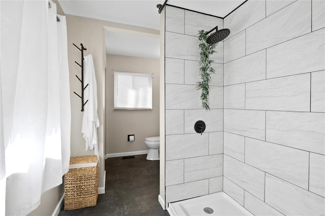 bathroom featuring toilet, concrete flooring, and tiled shower