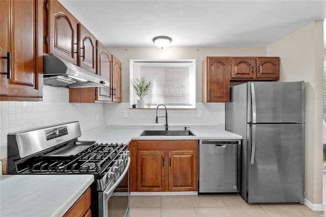 kitchen featuring light tile patterned floors, sink, appliances with stainless steel finishes, and tasteful backsplash