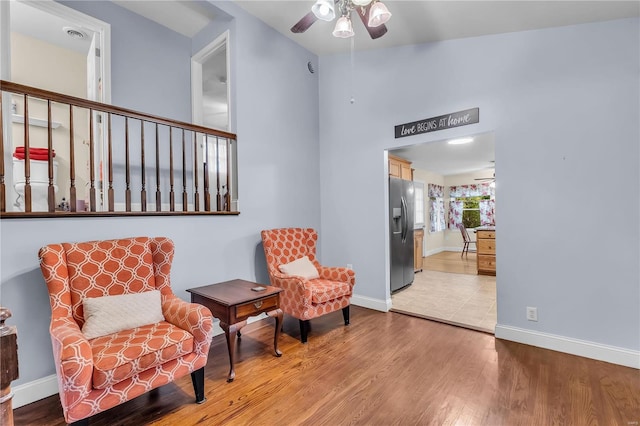 sitting room with light hardwood / wood-style floors and ceiling fan