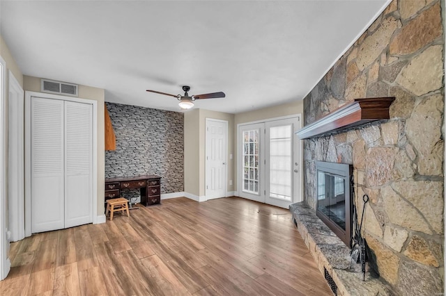 unfurnished living room featuring a fireplace, ceiling fan, and hardwood / wood-style floors