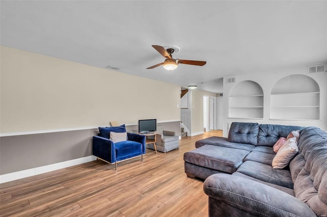 living room with ceiling fan, hardwood / wood-style floors, and built in shelves