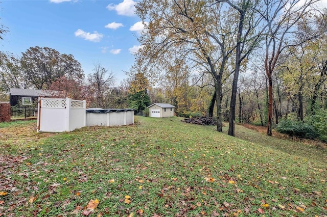 view of yard featuring a covered pool and a shed