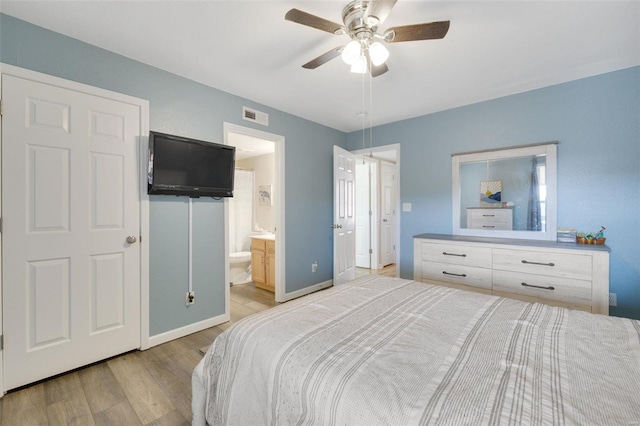 bedroom featuring ensuite bathroom, light hardwood / wood-style flooring, and ceiling fan