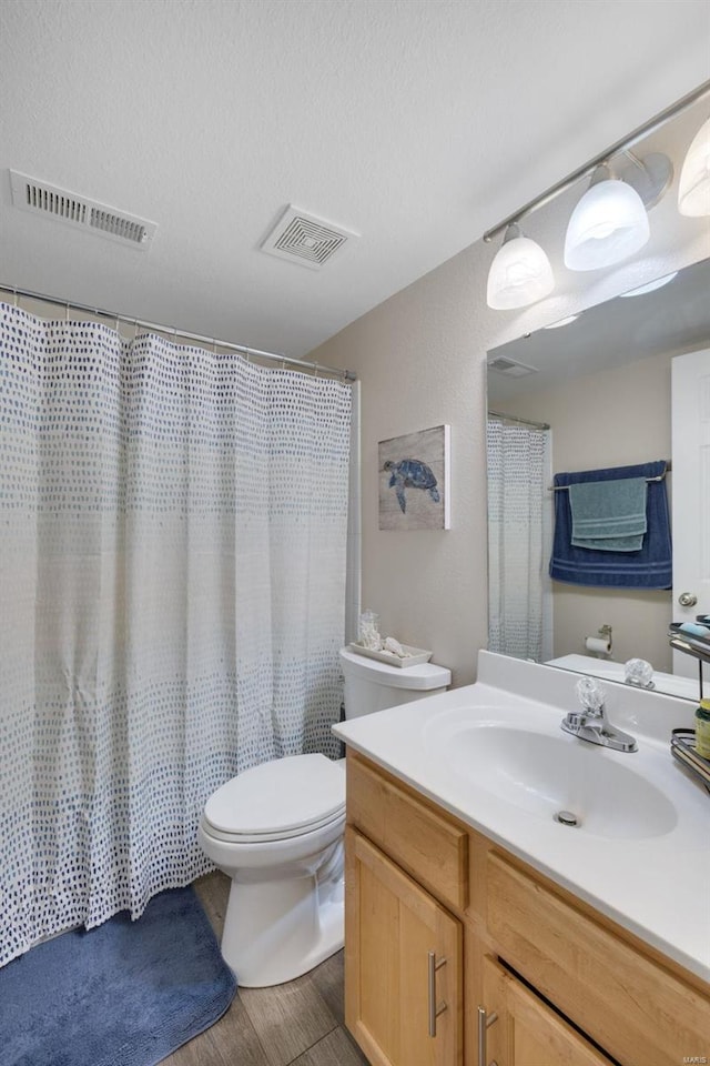 bathroom with vanity, a shower with shower curtain, toilet, a textured ceiling, and wood-type flooring