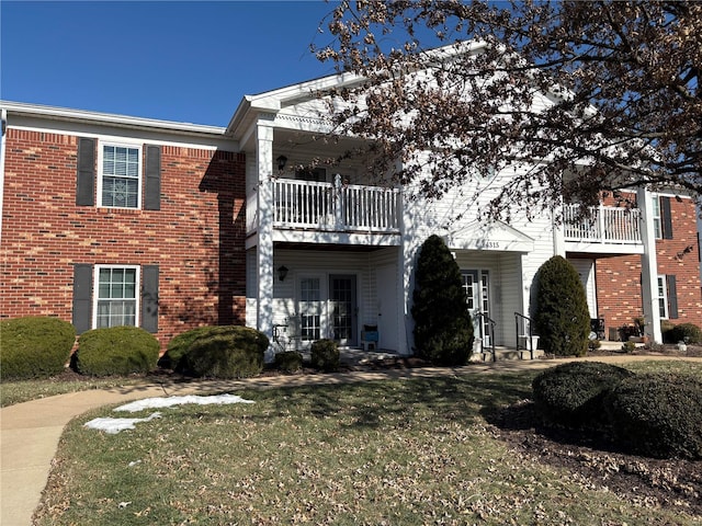 view of front of property with a balcony and a front yard