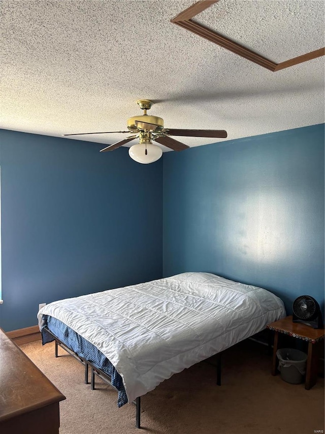 carpeted bedroom with ceiling fan and a textured ceiling