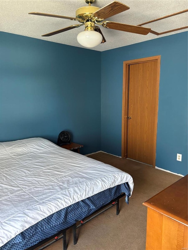 bedroom with ceiling fan, carpet floors, and a textured ceiling