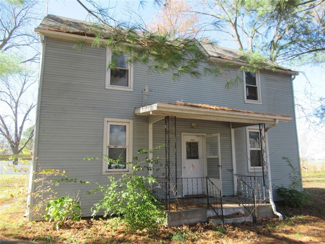 rear view of property featuring covered porch