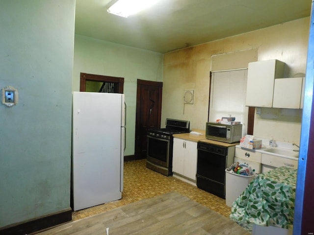 kitchen with white cabinetry, light hardwood / wood-style flooring, and stainless steel appliances