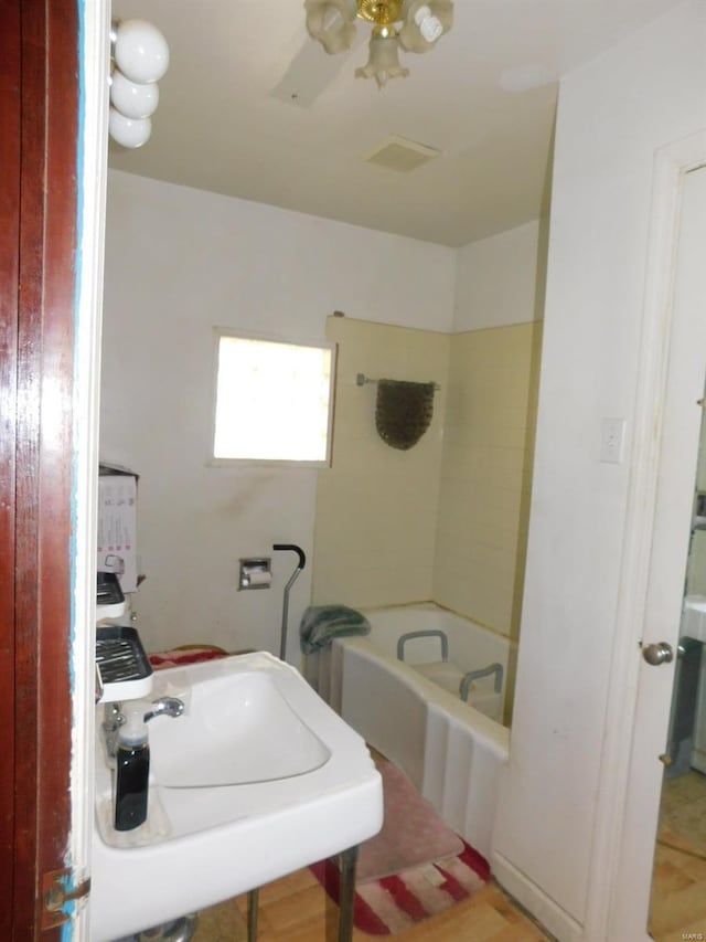 bathroom featuring ceiling fan, sink, and a bath