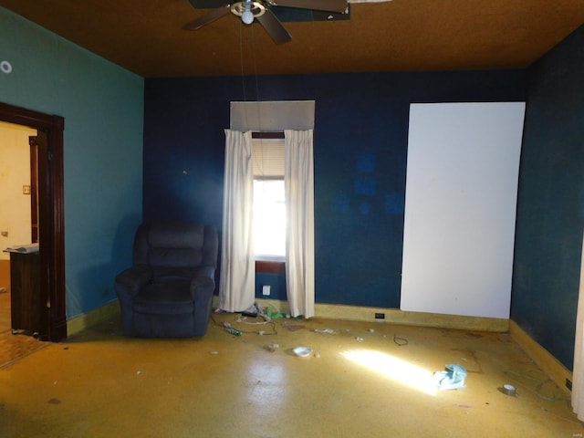 unfurnished living room featuring ceiling fan and concrete floors