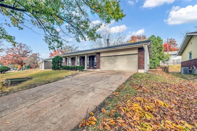 single story home featuring cooling unit, a garage, and a front lawn