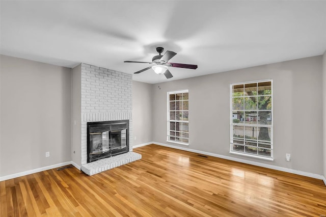 unfurnished living room with hardwood / wood-style floors, ceiling fan, and a fireplace