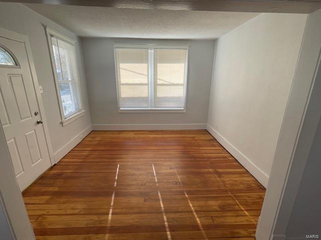 entryway with a textured ceiling and dark wood-type flooring