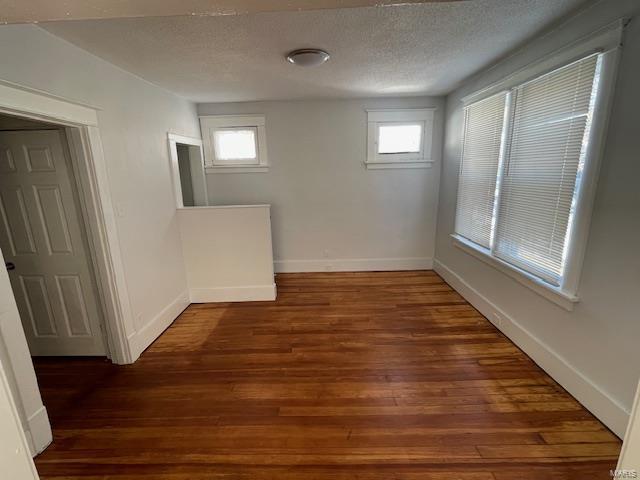 empty room featuring dark hardwood / wood-style floors and a textured ceiling