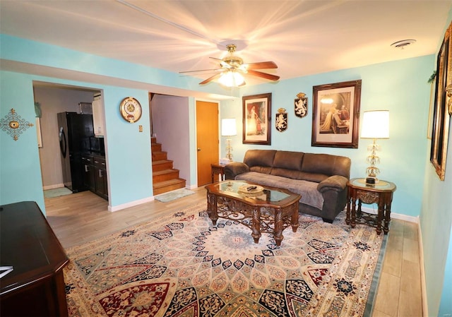 living room featuring light hardwood / wood-style floors and ceiling fan