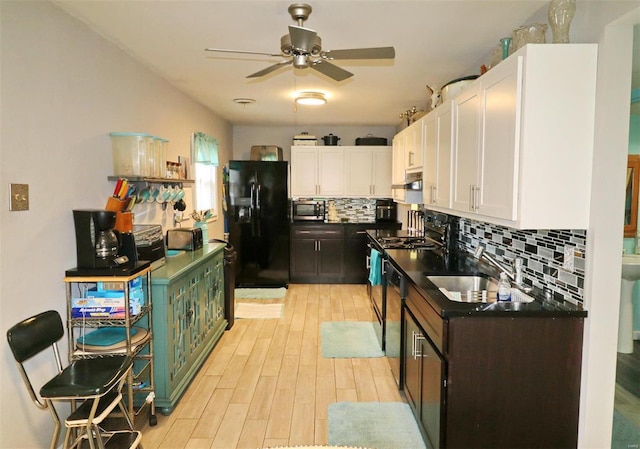 kitchen featuring ceiling fan, sink, black appliances, light hardwood / wood-style floors, and white cabinetry