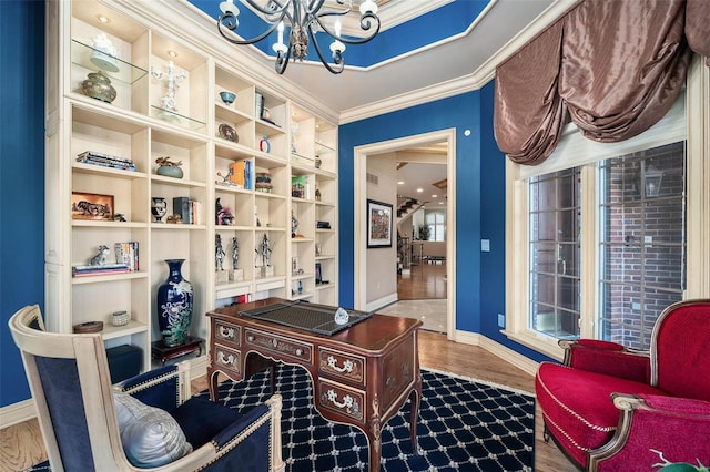 office with wood-type flooring, ornamental molding, and an inviting chandelier