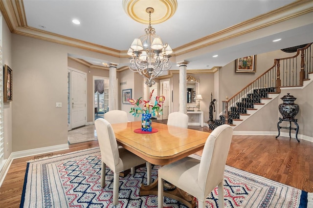 dining area with decorative columns, ornamental molding, and light hardwood / wood-style flooring