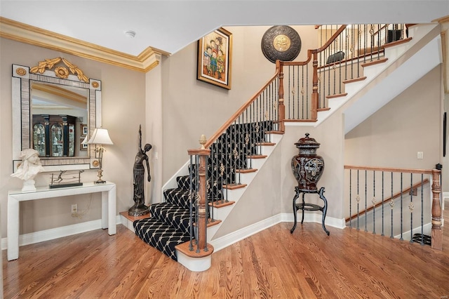 stairway with crown molding and hardwood / wood-style flooring