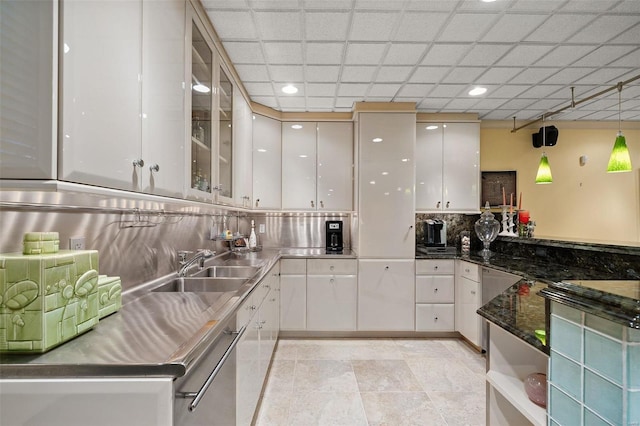 kitchen with sink, stainless steel dishwasher, decorative light fixtures, decorative backsplash, and white cabinets