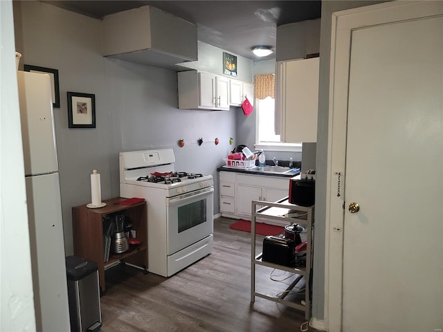 kitchen with wood-type flooring, sink, white cabinets, and white appliances