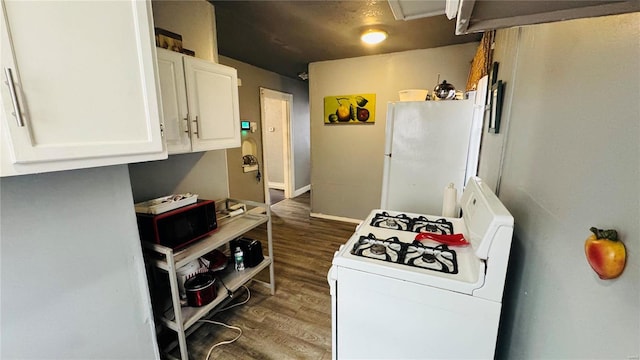 kitchen with dark wood-type flooring, white appliances, and white cabinets