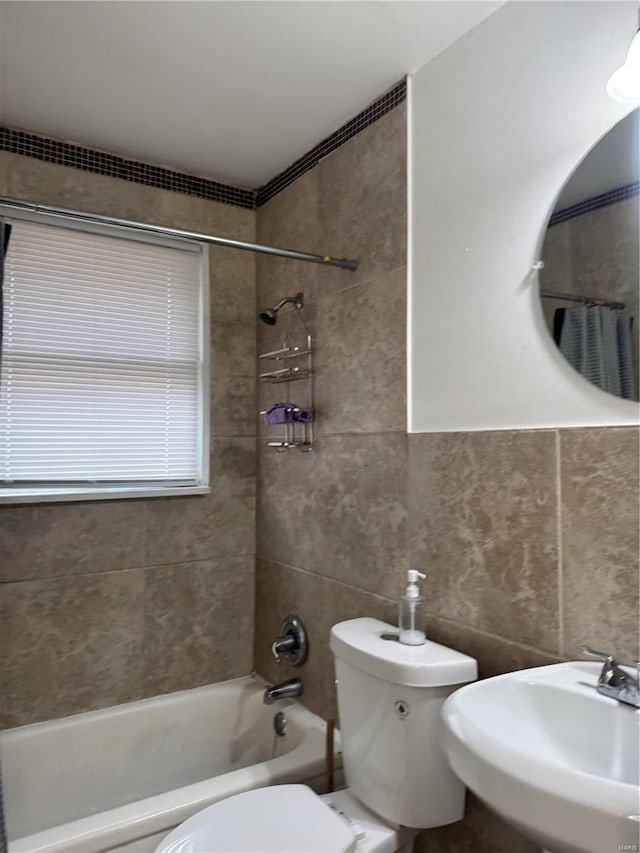 full bathroom featuring sink, tile walls, shower / tub combo with curtain, and toilet