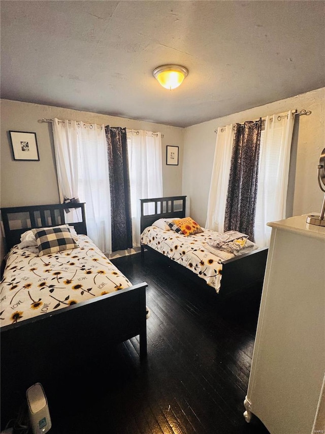 bedroom with dark hardwood / wood-style floors and a textured ceiling