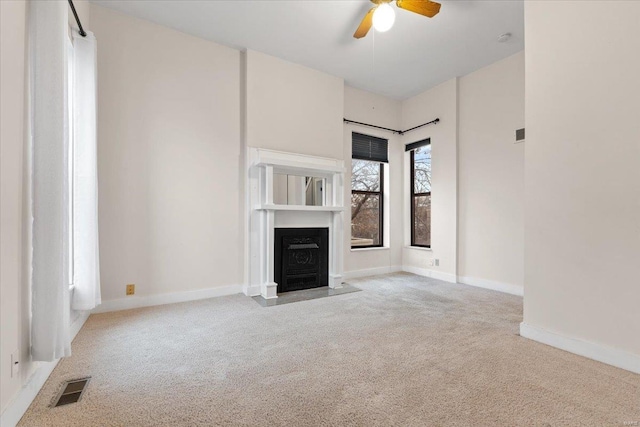 unfurnished living room featuring light colored carpet and ceiling fan