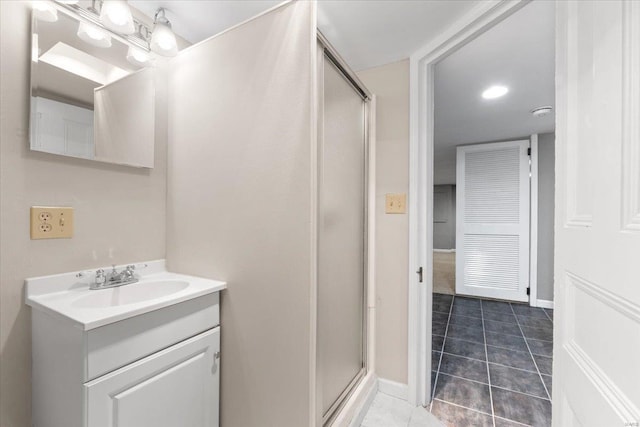 bathroom with an enclosed shower, vanity, and tile patterned flooring