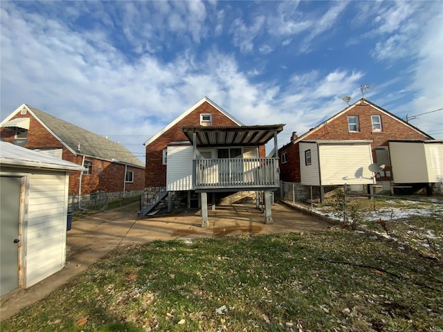 back of property with a wooden deck and a lawn