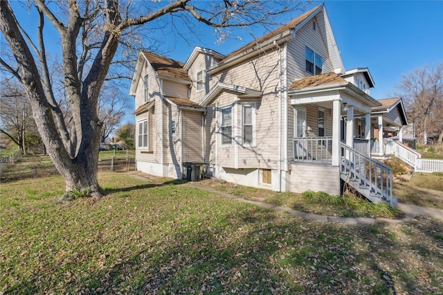 view of property exterior with covered porch and a lawn