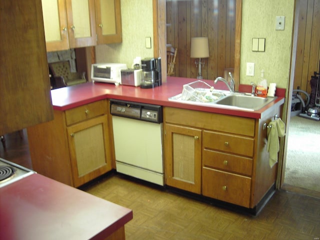 kitchen with kitchen peninsula, sink, white dishwasher, and parquet flooring