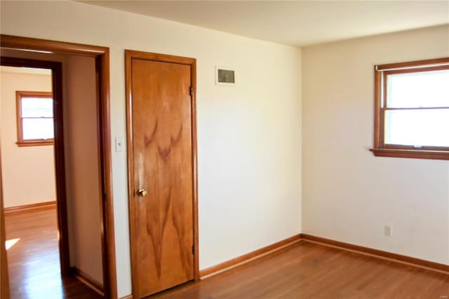 unfurnished room with a wealth of natural light and wood-type flooring