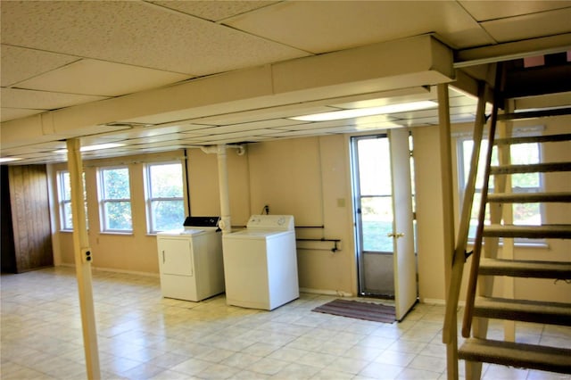 basement featuring a paneled ceiling and independent washer and dryer